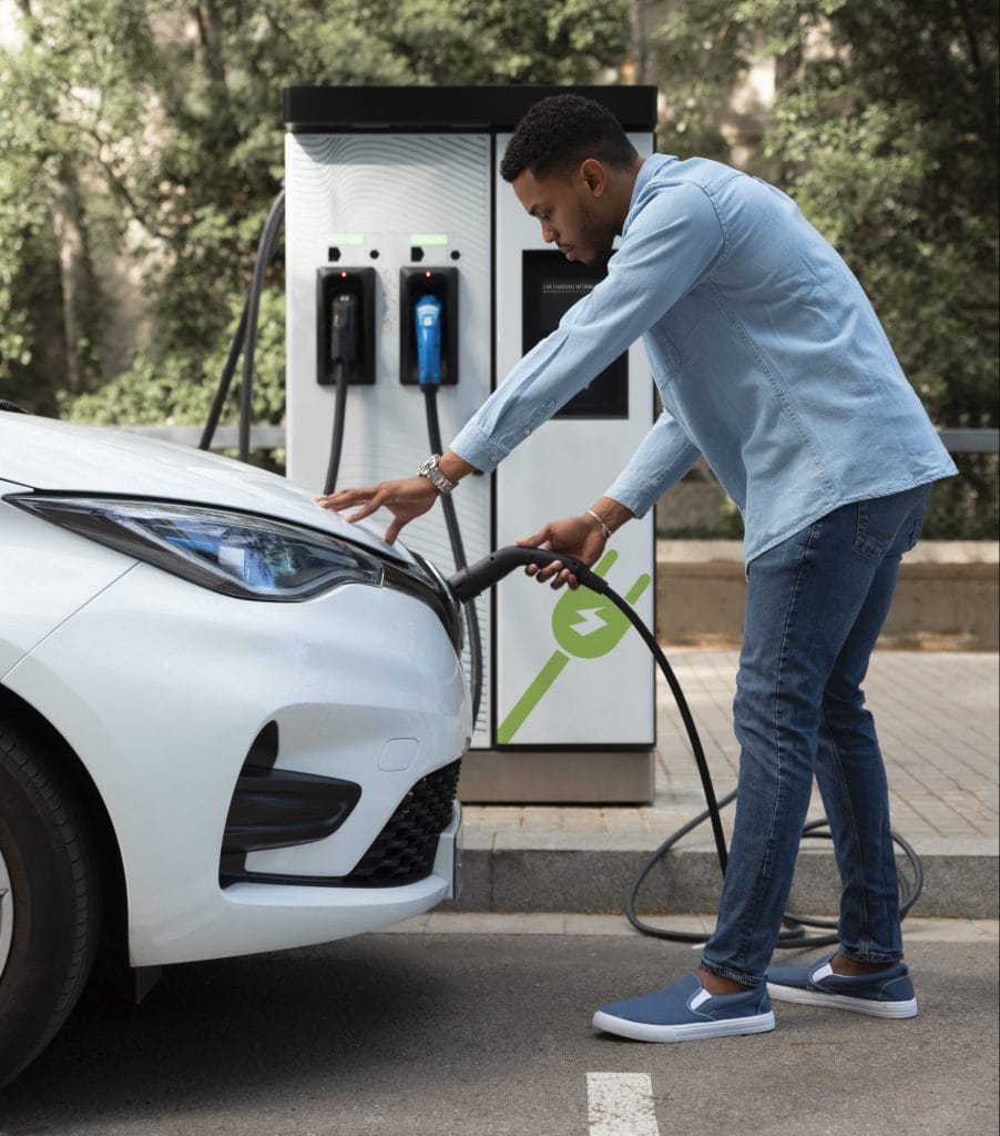 Man charging an electric car at a commerical EV station.