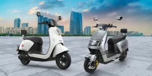Two electric bikes with a city skyline background.